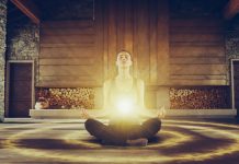 Malakchi to “transcend the ordinary” via investment fund Woman sitting in yoga pose with bright light around her