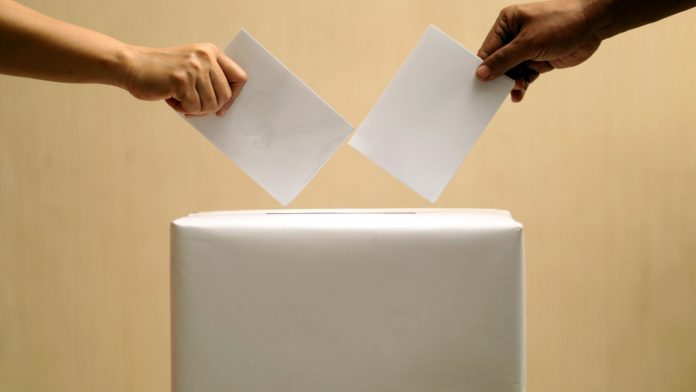 Close up of ballots being put in election box