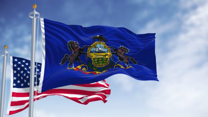 Pennsylvania flag with a US flag behind it