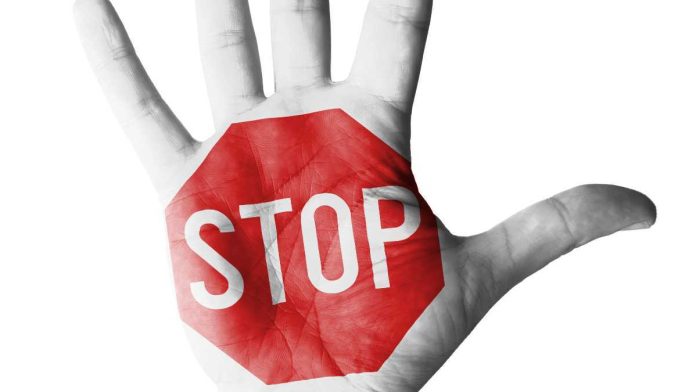 Hand with stop sign painted on it