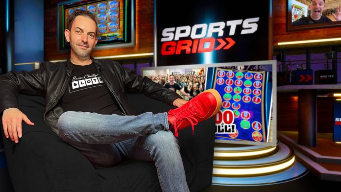 Brian Christopher sits on a chair with the SportsGrid logo behind him