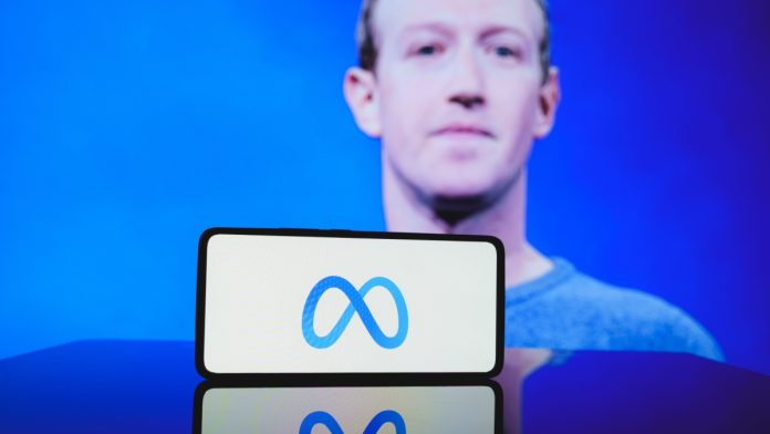 Mark Zuckerberg with Meta logo on phone in front of him