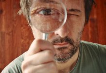 Australian Senator calls for probe on gambling industry influence Man looking through microscope