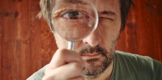 Australian Senator calls for probe on gambling industry influence Man looking through microscope