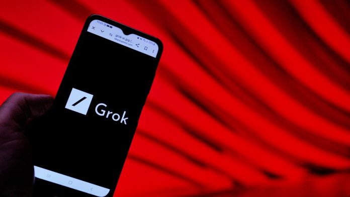 Grok logo on a phone screen in front of a red background